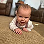 baby, blurred_background, carpet, child, cozy, crawling, cute, floor, furniture, hand, happy, head, home, indoors, infant, living_room, person, skin, sleeve, smiling