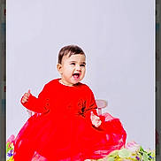 Arjoyi Kaur joined the competition — help win amazing prizes! baby, child, red_dress, smiling, happy, sitting, chair, flowers, barefoot, portrait, cute, toddler, indoor, studio, innocence, joy, celebration, bright, colorful, fashion