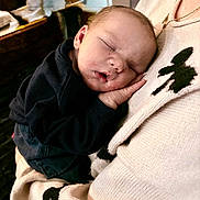 Thibault a rejoint le concours — aidez-le/la à gagner de superbes lots ! baby, sleeping, infant, child, person, sweater, hand, face, cozy, warm, comfort, rest, peaceful, closeup, portrait, indoor, soft_lighting, black_clothing, skin, cuddle
