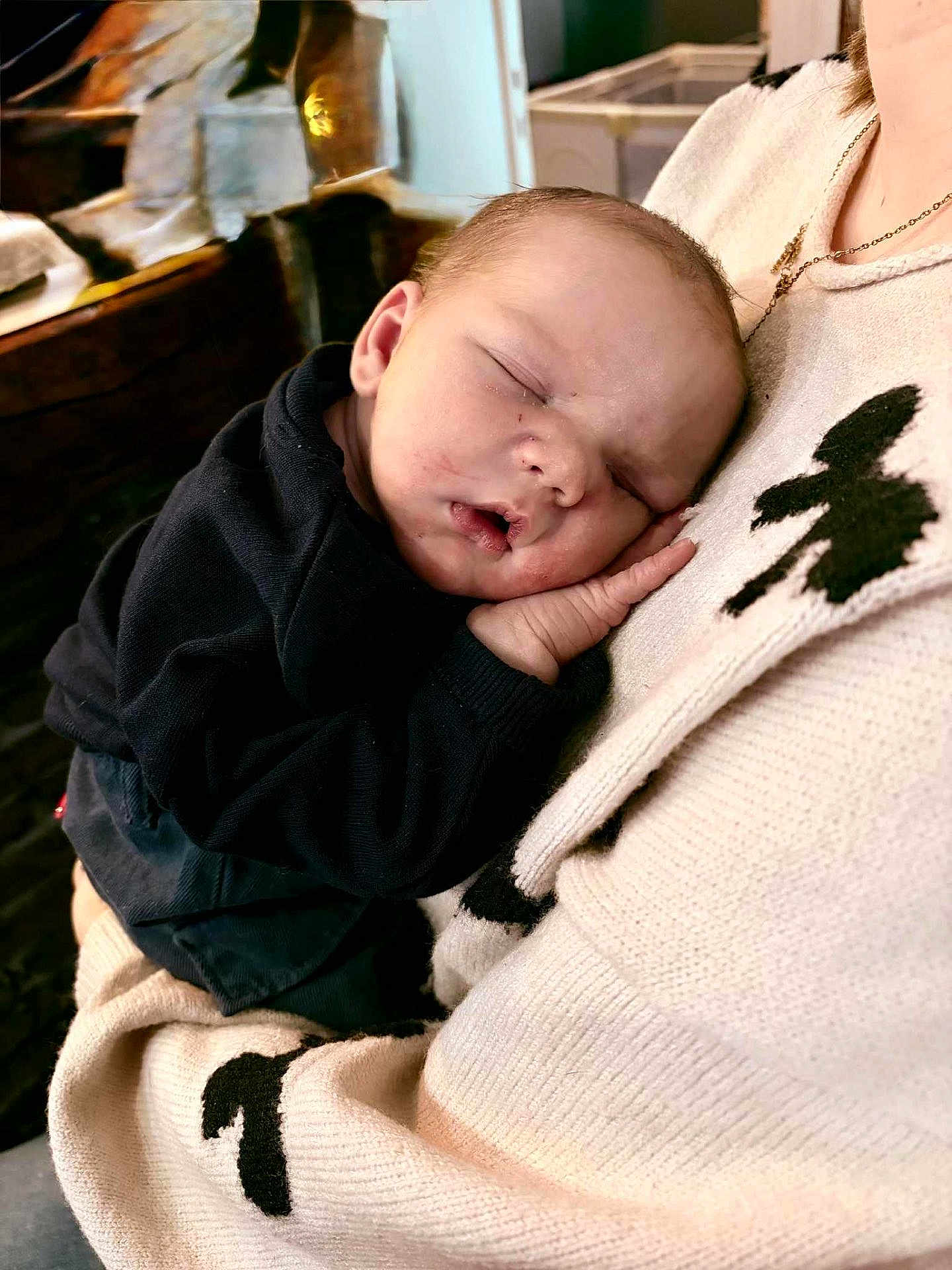Thibault a rejoint le concours — aidez-le/la à gagner de superbes lots ! baby, sleeping, infant, child, person, sweater, hand, face, cozy, warm, comfort, rest, peaceful, closeup, portrait, indoor, soft_lighting, black_clothing, skin, cuddle