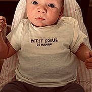 Thibault participe au concours pour gagner de l'argent avec cette photo : baby, child, clothing, cushion, cute, expression, eyes, face, glass, head, indoor, infant, person, portrait, shirt, sitting, skin, table, text, young