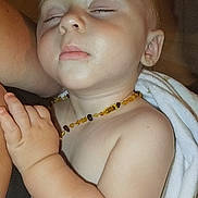 Wayne participe au concours pour gagner de l'argent avec cette photo : amber, arm, baby, blanket, calm, child, closeup, cozy, cute, hand, indoor, infant, necklace, peaceful, portrait, resting, serene, skin, sleeping, young