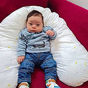 Zayn a rejoint le concours — aidez-le/la à gagner de superbes lots ! baby, child, cushion, cute, expression, eyes, face, hair, hand, indoor, infant, jeans, pillow, portrait, red_sofa, shoes, sitting, sneakers, sweater, white_bedding