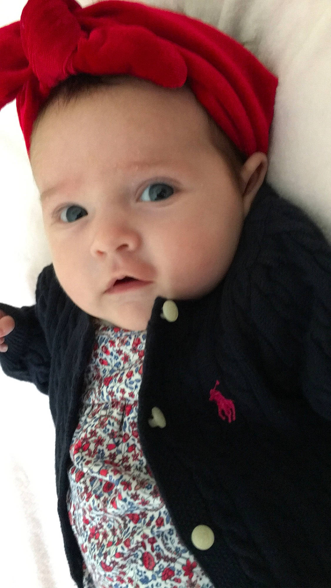 Dottie is registered to the contest to win money with this photo: baby, cheek, child, child_model, chin, eye, face, forehead, hair_accessory, head, headband, headgear, lip, nose, outerwear, person, pink, red, skin, smile
