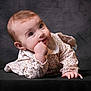 Mencia a rejoint le concours — aidez-le/la à gagner de superbes lots ! baby, black_background, child, clothing, crawling, curious, cute, expression, face, hand, indoors, infant, looking_up, one_person, portrait, skin, sleeves, soft_lighting, studio, young
