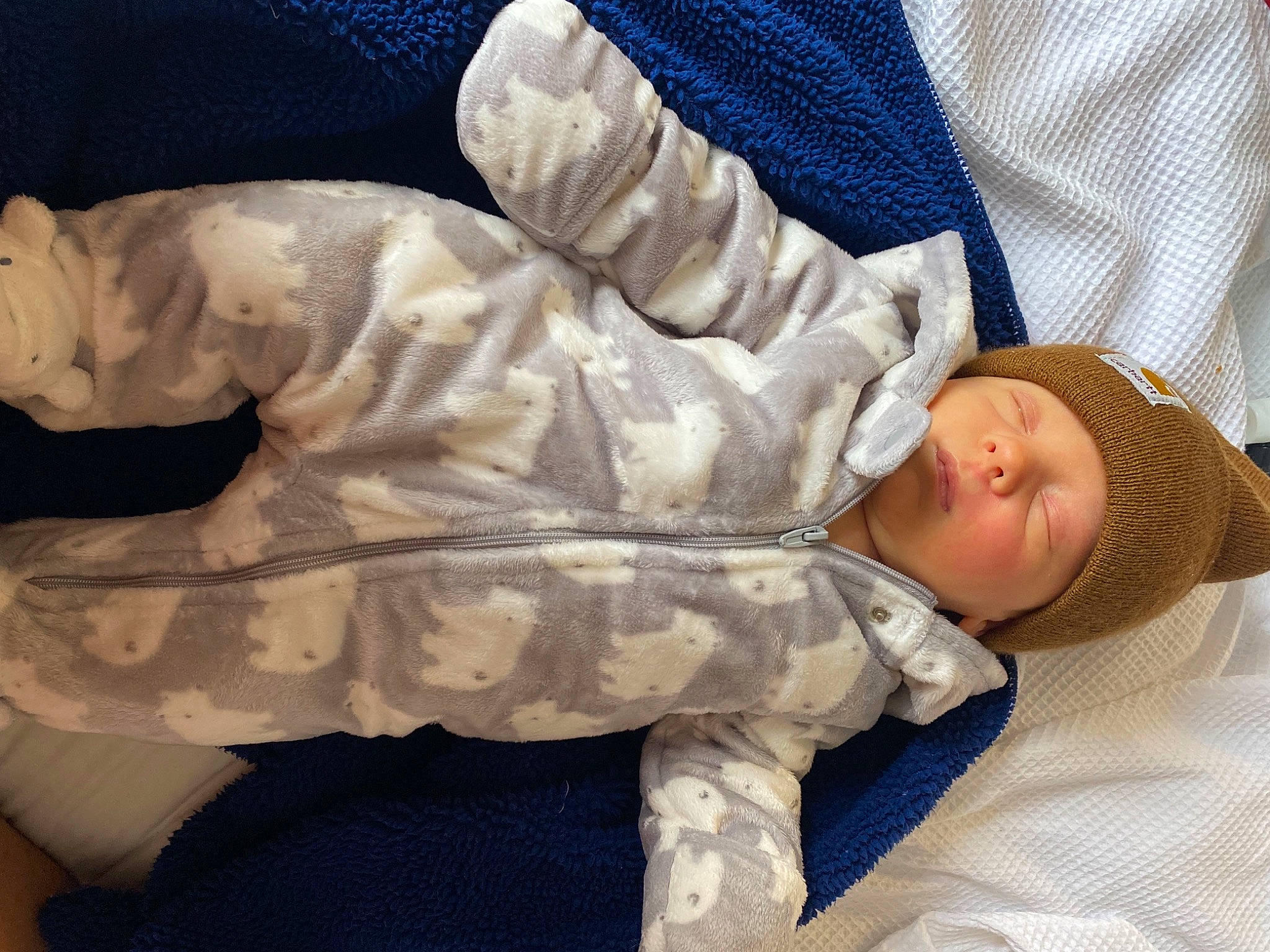 Kohen is registered to the contest to win money with this photo: arm, baby, baby_products, baby_sleeping, bed, comfort, elbow, finger, gesture, hand, headwear, human_body, joint, leg, linens, person, skin, sleeve, textile, thigh