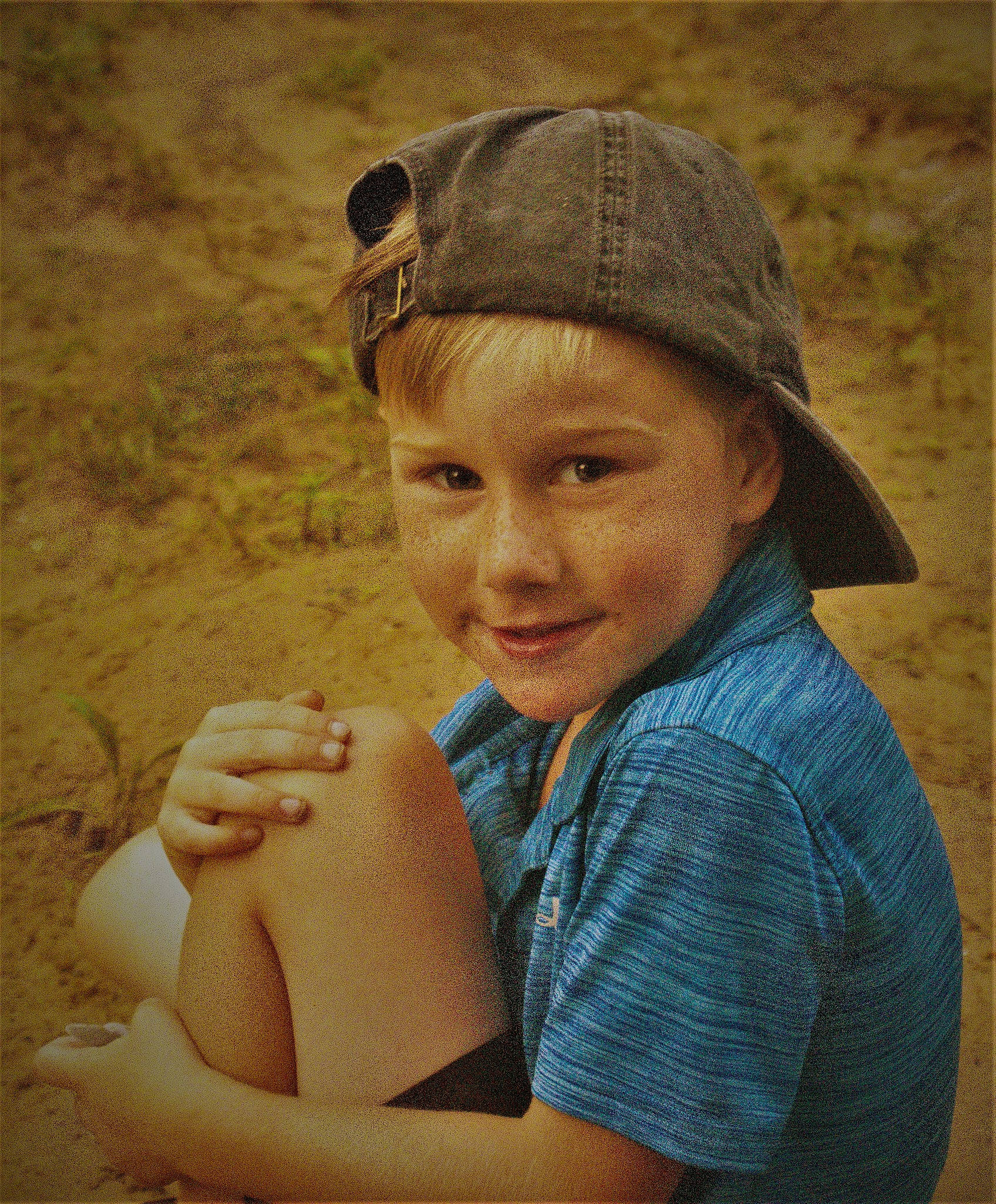 Jason is registered to the contest to win money with this photo: baseball_cap, cap, child, clothing, face, flash_photography, fun, grass, happy, hat, headgear, headwear, human, human_body, human_leg, joy, lip, people_in_nature, person, skin