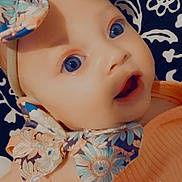 Aurora is registered to the contest to win money with this photo: accessories, applique, baby, bodypart, bonnet, cap, clothing, costume, doll, dress, face, finger, flower, flowerarrangement, flowerbouquet, formalwear, hand, hat, head, headband