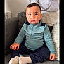 toddler, child, sofa, couch, indoor, sitting, clothing, socks, face, person, young_child, home, portrait, casual, furniture, expression, comfort, wall_texture, pillow, bag
