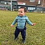 blue_clothing, building, casual, child, cloudy, daylight, determined, expression, field, grass, nature, outdoor, person, portrait, shoes, sky, sportswear, standing, toddler, young_child