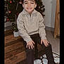 Milhan a rejoint le concours — aidez-le/la à gagner de superbes lots ! boots, boy, carpet, child, christmas_tree, cozy, festive, happy, holiday, holiday_decorations, home, indoor, pants, plant, portrait, seasonal, smile, smiling, sweater, wooden_bench