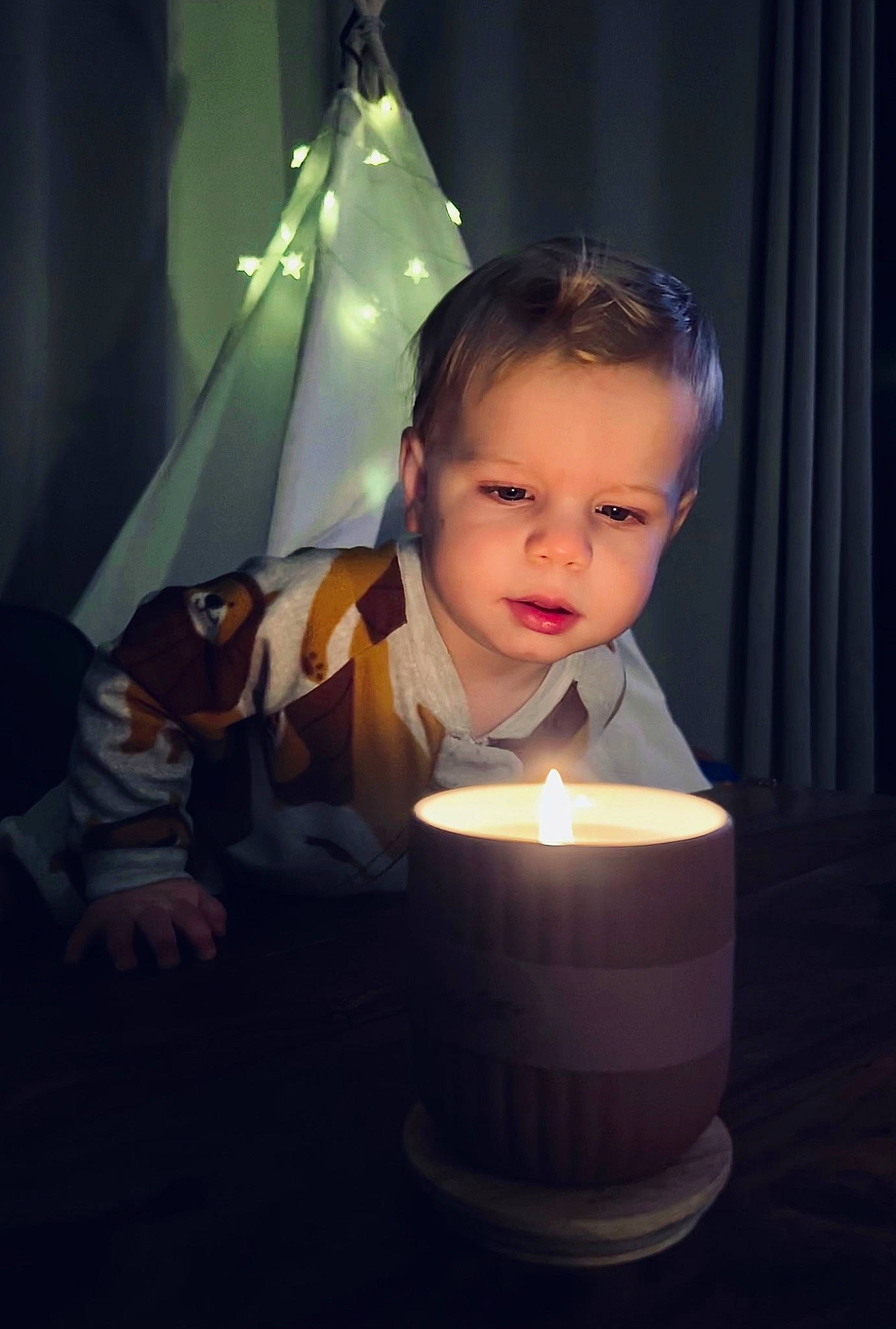 Judah is registered to the contest to win money with this photo: art, candle, child, curtain, darkness, event, facial_hair, fire, flame, flash_photography, fun, happy, heat, lighting_accessory, night, person, room, sitting, toddler, wax