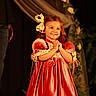 Callie joined the competition — help win amazing prizes! child, girl, smile, dress, bow, stage, happy, clothing, person, portrait, hands, red_dress, curly_hair, adult, jeans, warm_lighting, event, celebration, flower_decoration, background