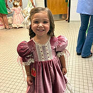 Callie is registered to the contest to win money with this photo: child, girl, smile, dress, bow, indoor, people, floor, tile_floor, door, woman, person, costume, pageant, event, background, happy, lace, curly_hair, bracelet