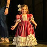 Callie is registered to the contest to win money with this photo: child, girl, dress, vintage_dress, bow, smile, stage, tattoo, adult, arm, legs, footwear, dark_background, happy, posing, performance, long_hair, lace, puffed_sleeves, floor