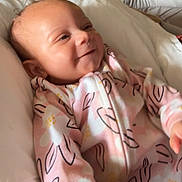 Evealyn joined the competition — help win amazing prizes! apparel, baby, child, cozy, cute, face, floral_pattern, happy, head, indoors, infant, lying_down, newborn, onesie, pink, portrait, skin, smile, soft_surface, young_child