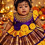 Riddhita joined the competition — help win amazing prizes! baby, infant, child, traditional_dress, purple_dress, yellow_dress, bindi, headband, jewelry, curly_hair, dark_hair, portrait, sitting, candles, diyas, marigolds, floral_decor, festive, bokeh, adorable