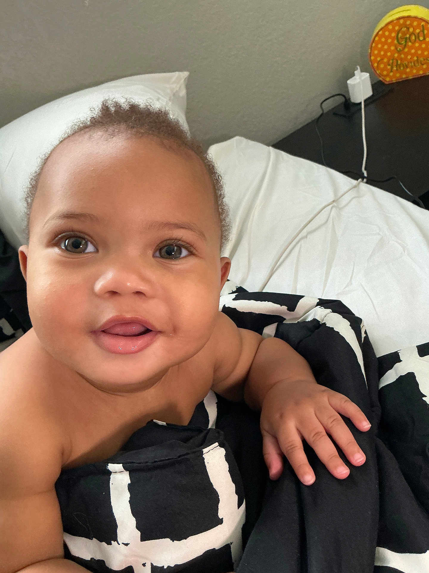 Asión is registered to the contest to win money with this photo: baby, bed, black, blanket, child, closeup, cute, eyes, face, furniture, hand, indoor, infant, mouth, pattern, pillow, skin, smiling, white, young
