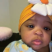 Zynori joined the competition — help win amazing prizes! baby, child, face, headwrap, flower, orange, blue_clothing, floral_pattern, indoor, portrait, cute, infant, closeup, looking, young_child, head_accessory, expression, skin, person, apparel