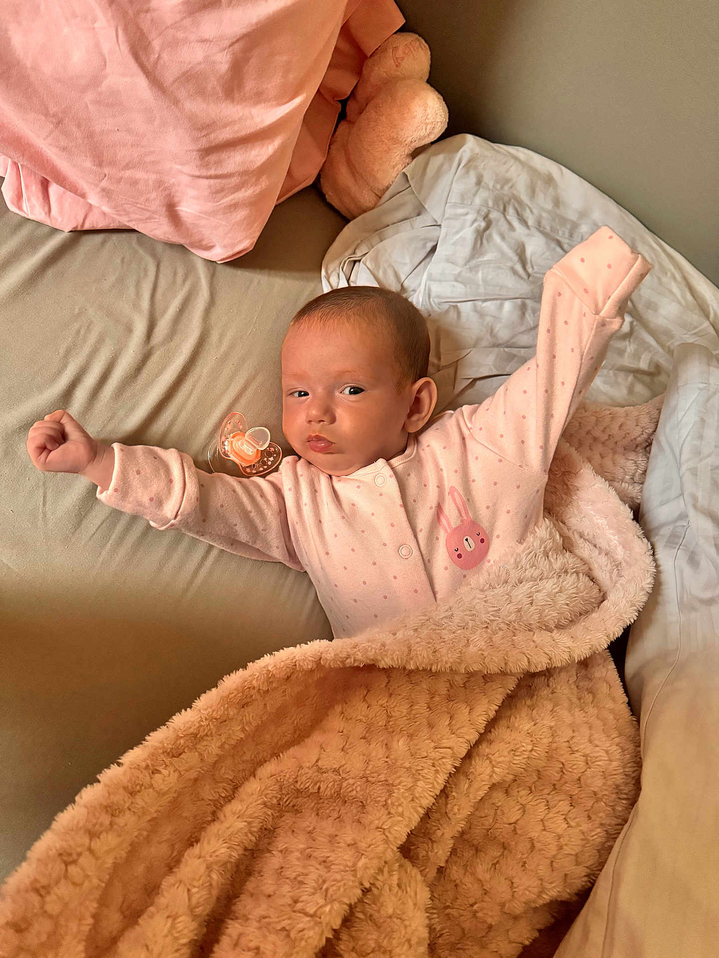 Miia is registered to the contest to win money with this photo: baby, infant, blanket, pacifier, bed, pajamas, pink, stretching, sleepy, cozy, soft, pillow, cute, child, indoors, resting, face, person, newborn, comfort