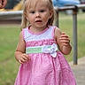 child, toddler, girl, dress, pink, white, green, bow, hair, outdoor, grass, sidewalk, curious, young_child, face, portrait, person, daylight, casual, standing