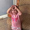 Oaklyn joined the competition — help win amazing prizes! butterfly, carpet, child, couch, cute, floral, furniture, hands, happy, heart_shape, home, indoor, person, pink_shirt, playing, shorts, smiling, standing, toddler, young_child