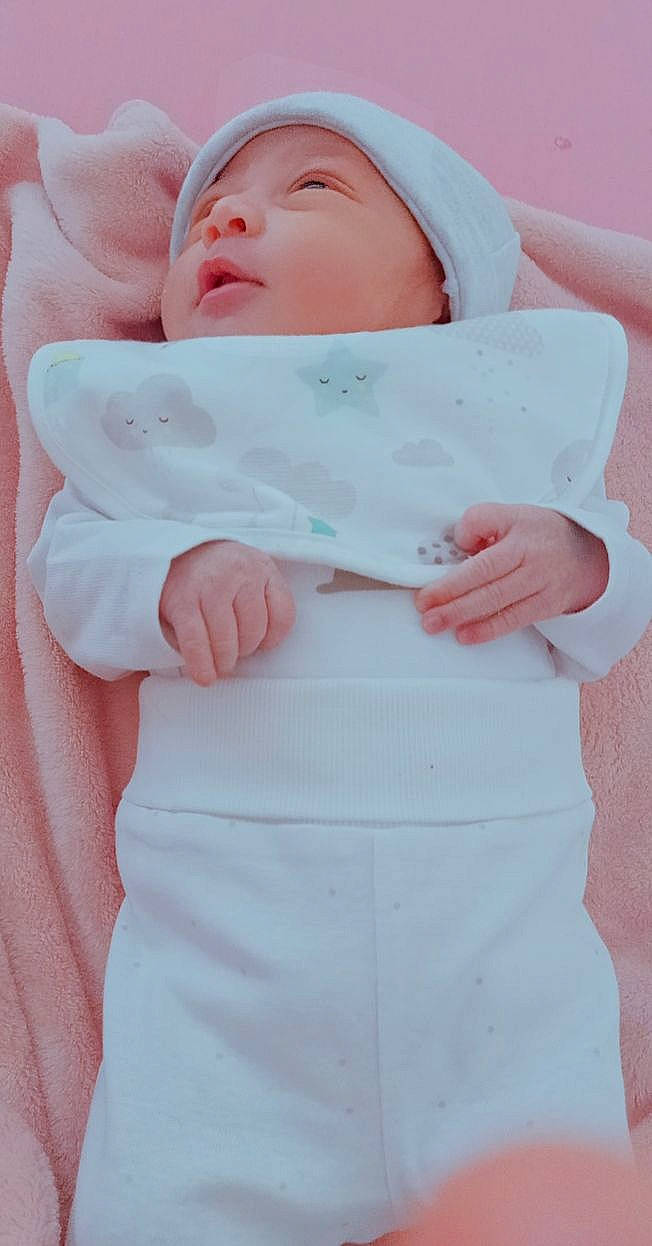 Nouzha participe au concours pour gagner de l'argent avec cette photo : arm, baby, baby_products, baby_toddler_clothing, button, cheek, child, collar, comfort, eye, face, fashion_accessory, gesture, linens, magenta, person, pink, sleeve, thumb, toddler