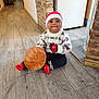 Riyansh a rejoint le concours — aidez-le/la à gagner de superbes lots ! toddler, child, baby, hat, winter_sweater, red_socks, basket, wooden_floor, indoors, brick_wall, doorway, home, cute, festive, smiling, sitting, floor, warm_clothing, young_child, holiday