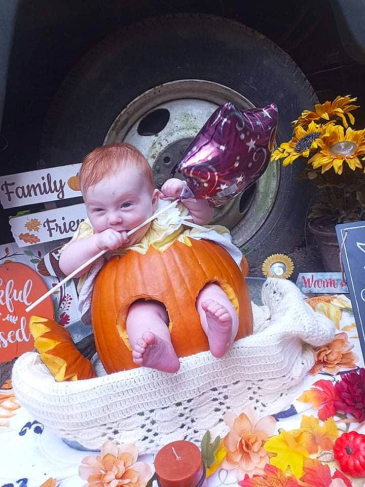 Makinsley is registered to the contest to win money with this photo: automotive_design, automotive_tire, baby, chair, child, event, fictional_character, fun, orange, person, plant, pumpkin, room, sitting, tableware, tire, toddler, tradition, vegetable, wheel