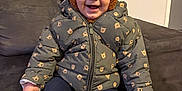 Kelyo a rejoint le concours — aidez-le/la à gagner de superbes lots ! toddler, child, smiling, jacket, hat, bear_ears, sitting, indoor, couch, footwear, happy, cute, warm_clothing, person, portrait, cozy, baby, face, expression, home