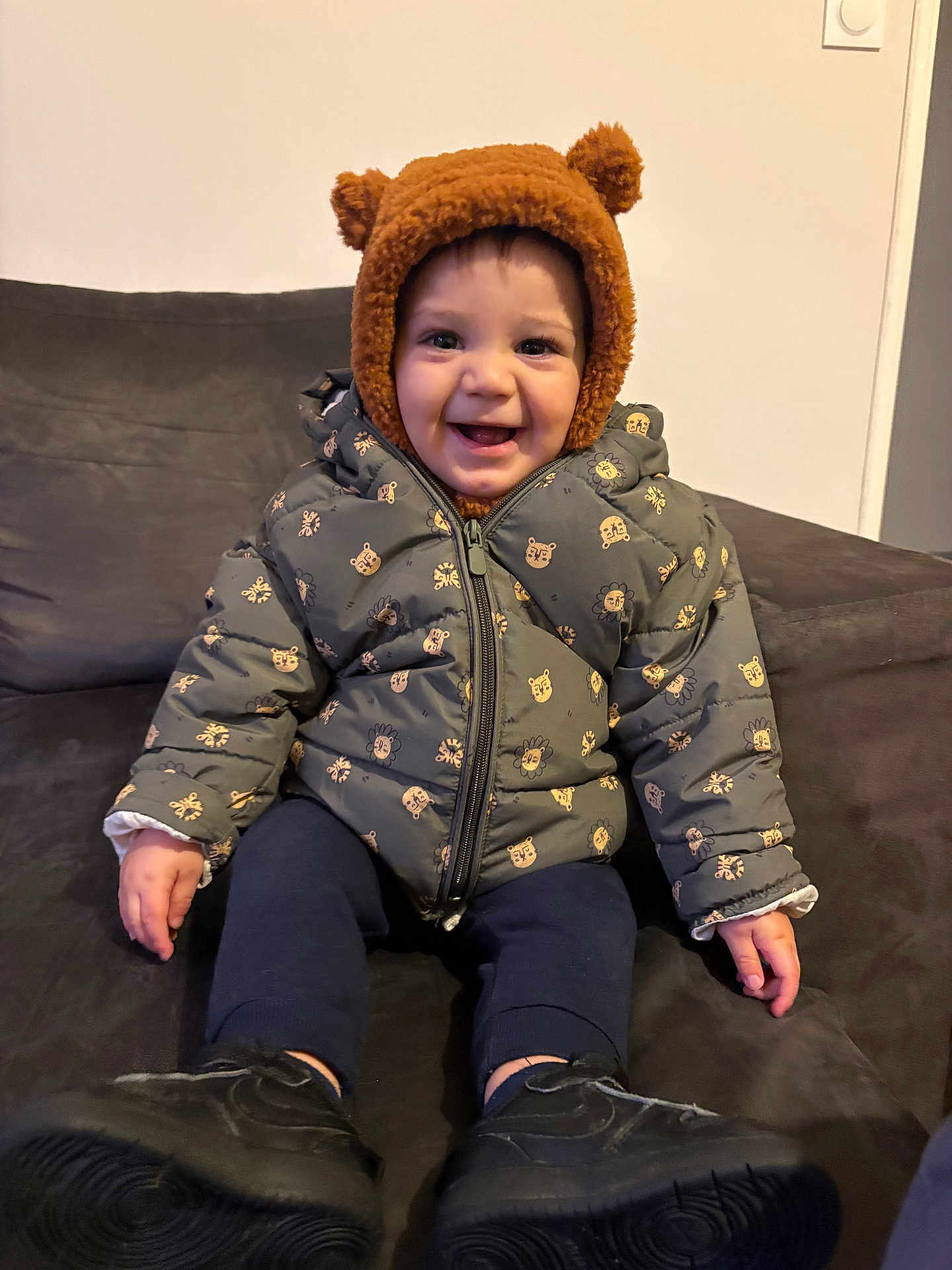 Kelyo a rejoint le concours — aidez-le/la à gagner de superbes lots ! toddler, child, smiling, jacket, hat, bear_ears, sitting, indoor, couch, footwear, happy, cute, warm_clothing, person, portrait, cozy, baby, face, expression, home
