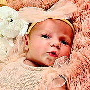 Sofia joined the competition — help win amazing prizes! baby, infant, headband, bow, ruffles, peach_clothing, pink_blanket, fluffy, stuffed_animal, soft_toy, close_up, portrait, face, cute, newborn, lying_down, curious, child, skin, adorable