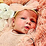 baby, infant, headband, bow, ruffles, peach_clothing, pink_blanket, fluffy, stuffed_animal, soft_toy, close_up, portrait, face, cute, newborn, lying_down, curious, child, skin, adorable