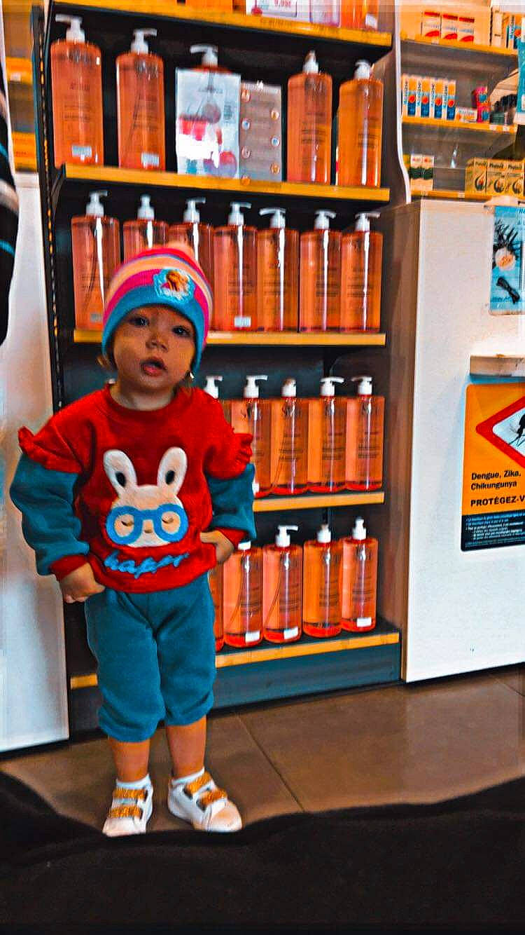 Mailine participe au concours pour gagner de l'argent avec cette photo : baby, baby_toddler_clothing, bookcase, cap, child, electric_blue, flooring, fun, headwear, orange, person, product, publication, retail, room, shelf, shelving, sleeve, sportswear, stuffed_toy