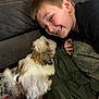 boy, carpet, casual_clothing, child, closeup, couch, cute, dog, friendship, fur, happy, home, indoor, light_brown_hair, pet, playful, resting, small_dog, smiling, young