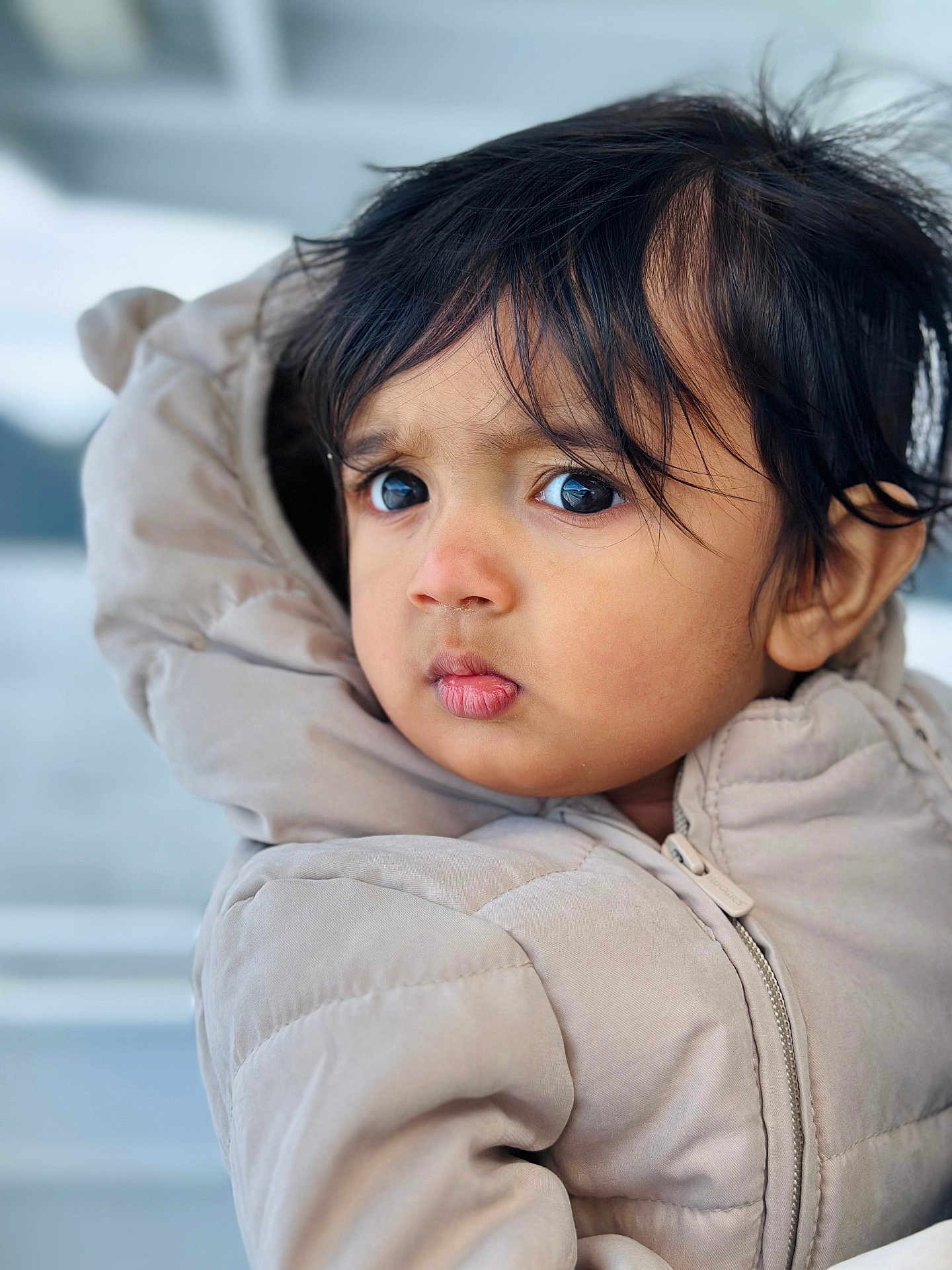 Viyaan is registered to the contest to win money with this photo: child, toddler, face, portrait, jacket, clothing, winter_wear, hair, eyes, expression, outdoor, cold_weather, cute, person, young_child, closeup, warm_clothing, curious, soft_light, head