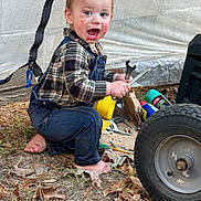 Noah is registered to the contest to win money with this photo: alloywheel, baby, car, carwheel, clothing, face, footwear, head, jeans, machine, pants, person, photography, portrait, soil, spoke, tire, transportation, vehicle, wheel