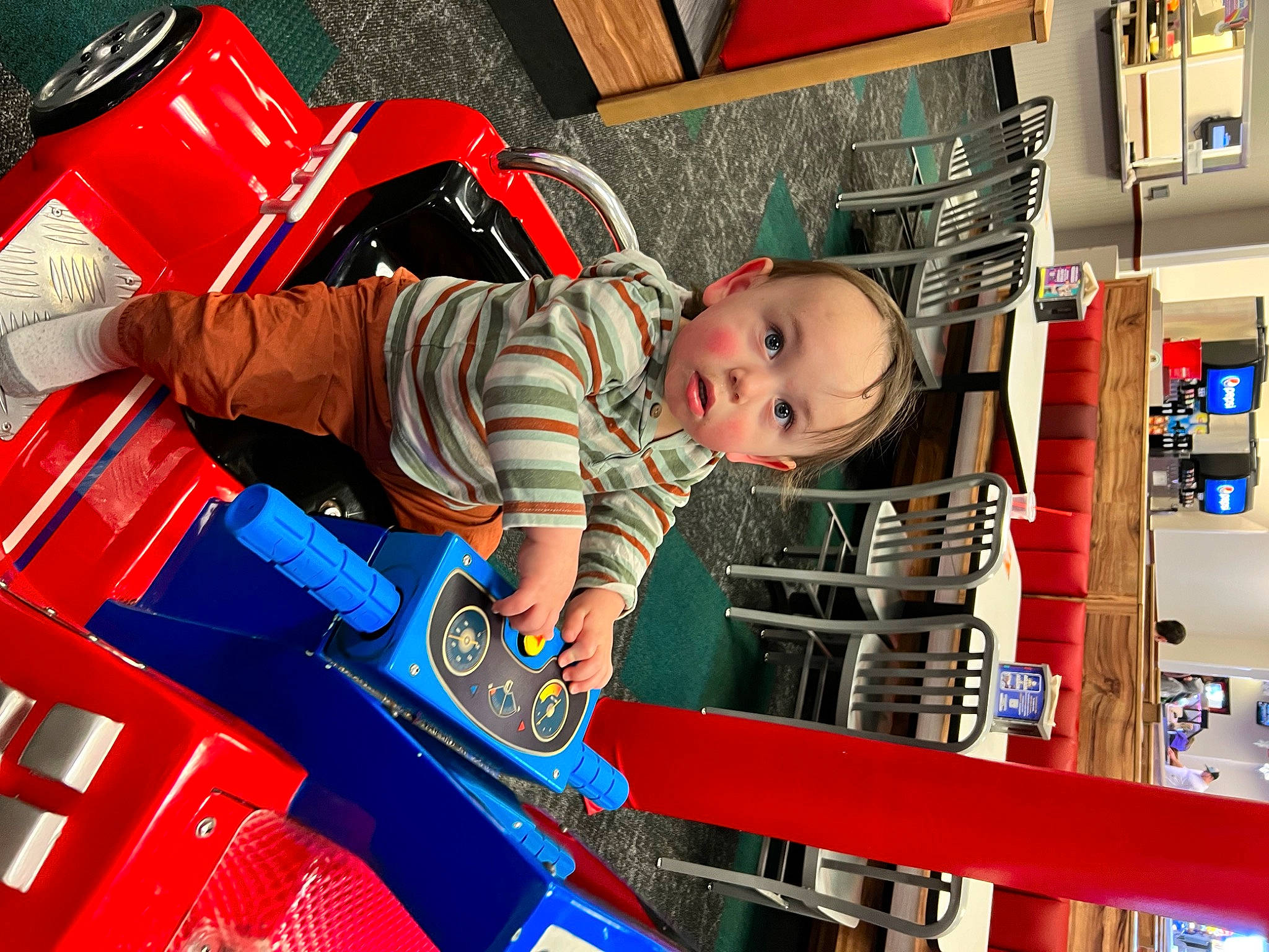 Jamison is registered to the contest to win money with this photo: automotive_design, automotive_exterior, baby, baby_products, baby_toddler_clothing, child, electric_blue, fun, motor_vehicle, person, play, red, retail, service, shelf, surprise, t_shirt, tire, toddler, toy