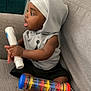 Zaccai joined the competition — help win amazing prizes! toddler, child, indoor, couch, sitting, hoodie, headwrap, barefoot, toy, colorful, plastic, tube, curious, baby, furniture, foot, clothing, person, expression, home