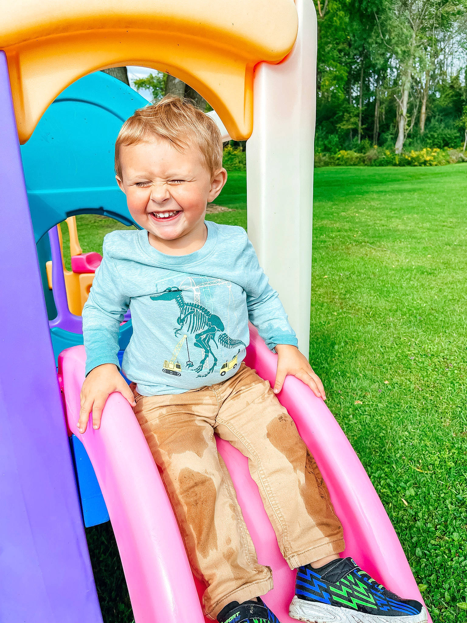 Landyn joined the competition — help win amazing prizes! baby_toddler_clothing, city, fun, grass, green, happy, joy, leisure, magenta, outdoor_play_equipment, people_in_nature, person, pink, playground, playground_slide, recreation, shorts, sitting, smile, t_shirt