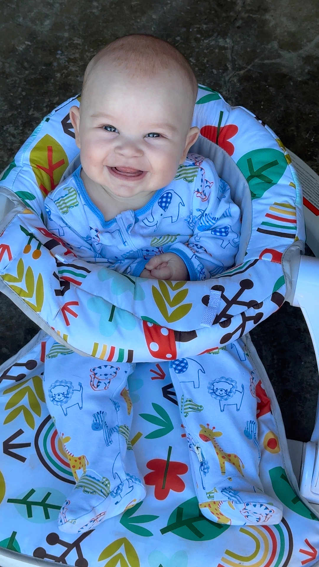 Stetson is registered to the contest to win money with this photo: baby, smiling, child, pajamas, animal_print, baby_seat, colorful, happy, cute, infant, face, sitting, footed_pajamas, patterned, indoors, clothing, comfort, joy, portrait, young