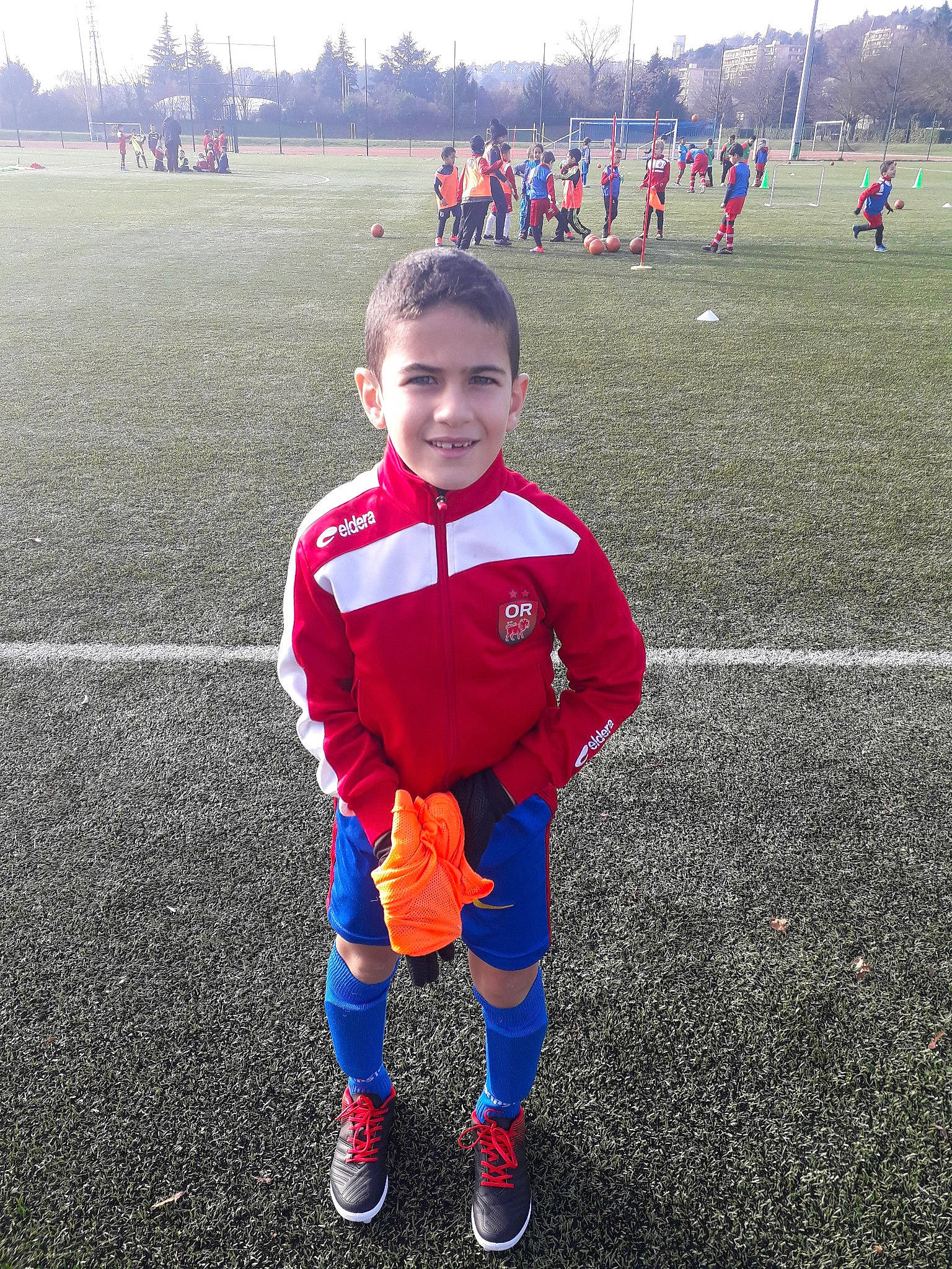 Chems Eddine participe au concours pour gagner de l'argent avec cette photo : ball, boy, child, clothing, competition_event, day, football, football_player, fun, joy, person, personal_protective_equipment, play, player, product, red, soccer_player, sports, team, team_sport