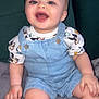 baby, child, smiling, denim_overalls, mickey_mouse, clothing, sitting, indoor, couch, blanket, happy, cute, portrait, face, person, infant, soft_texture, blue_eyes, short_hair, casual_wear