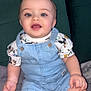 baby, child, blue_eyes, denim_overalls, mickey_mouse, shirt, smiling, sitting, blanket, cushion, green_cushion, cute, happy, indoors, portrait, face, hand, legs, toddler, clothing