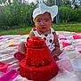 baby, child, headband, bow, watermelon, fruit, picnic_blanket, outdoor, grass, greenery, summer, cute, food, fruit_stack, nature, infant, sitting, colorful, headwear, sunlight
