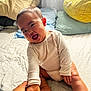 Hailey is registered to the contest to win money with this photo: baby, child, smiling, hand_holding, bed, pillow, onesie, indoor, happy, person, infant, cute, light, curtain, fabric, skin, foot, face, sitting, playful