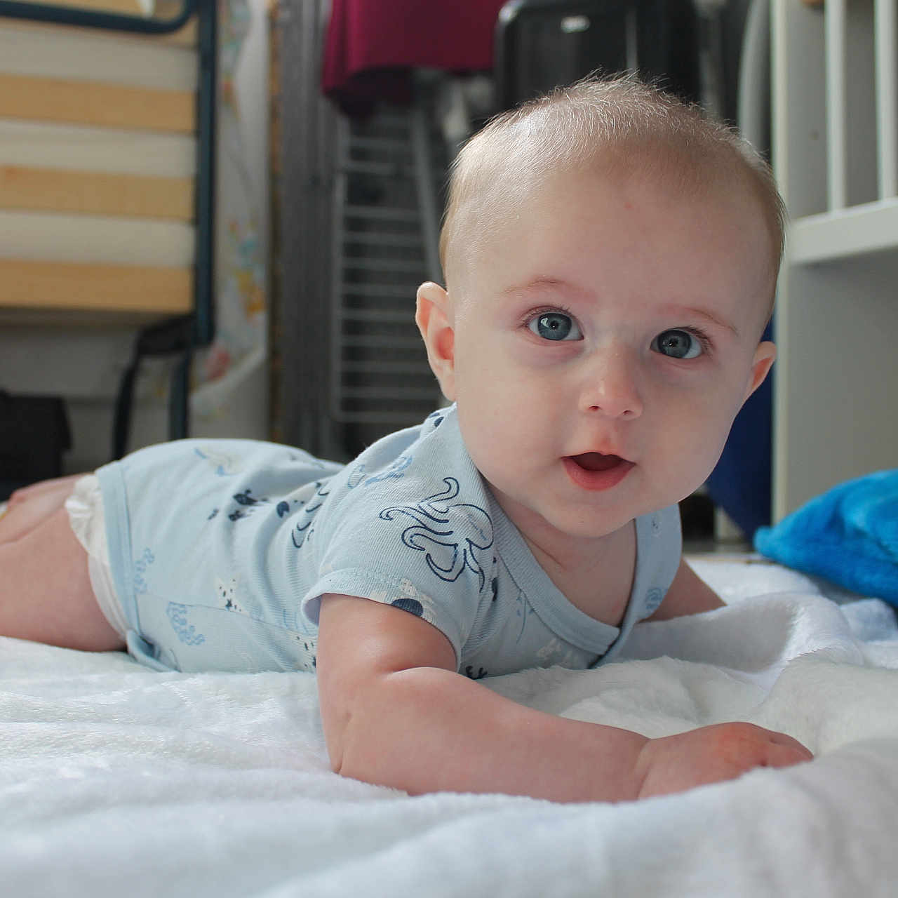 Owen participe au concours pour gagner de l'argent avec cette photo : baby, bed, blanket, blue_eyes, child, clothing, crawling, cute, face, floor, furniture, happy, home, indoor, infant, onesie, portrait, skin, soft, toddler