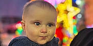 Owen a rejoint le concours — aidez-le/la à gagner de superbes lots ! baby, blue_jacket, blurred_background, buttoned_clothing, child, closeup, colorful_lights, curious_expression, cute, face, festive, holiday_lights, night, outdoor, person, portrait, smile, warm_clothing, winter, young_child