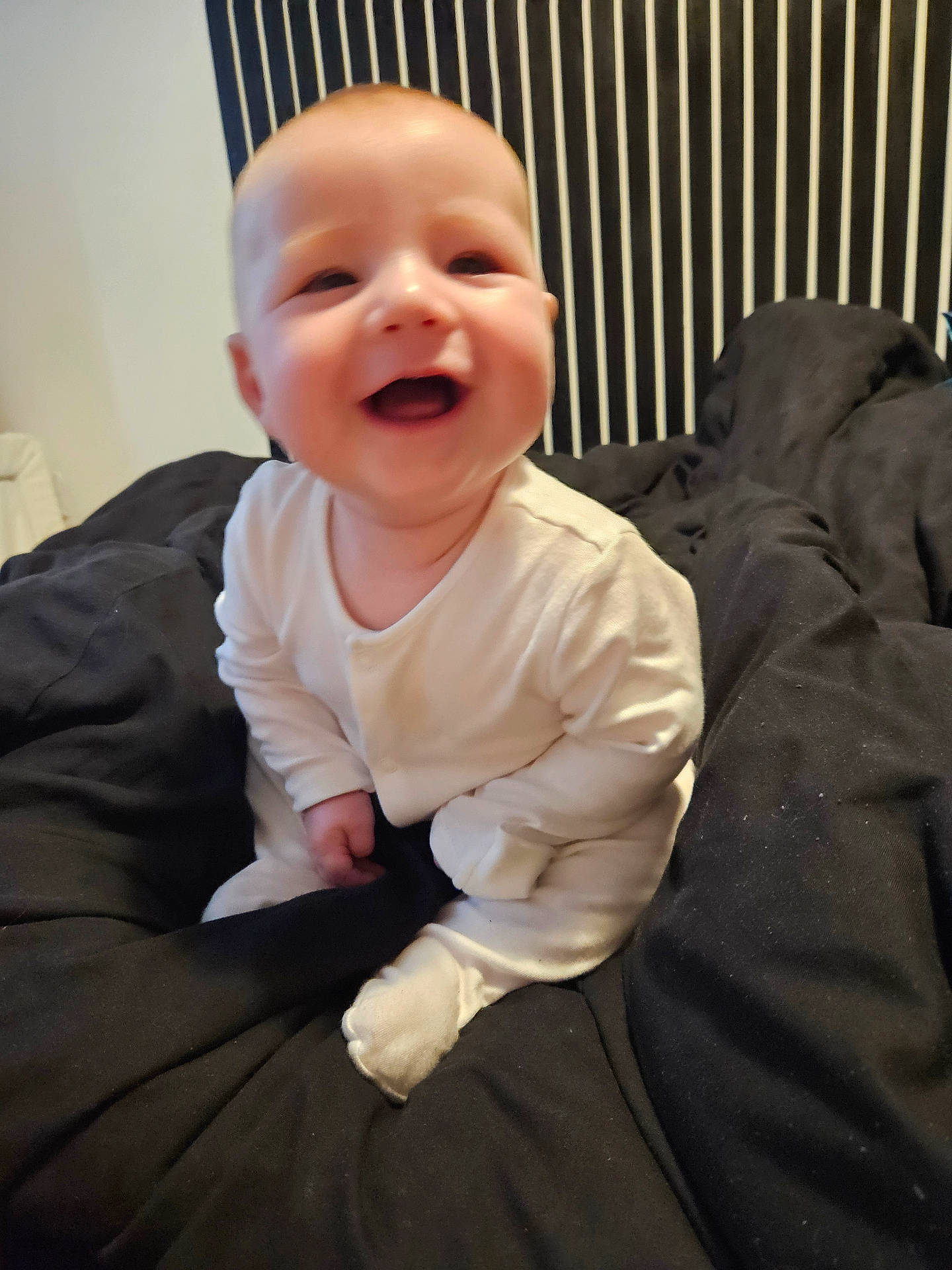 Luca joined the competition — help win amazing prizes! baby, babylaughing, bed, bedroom, clothing, couch, cushion, dress, face, furniture, happy, head, homedecor, laughing, pants, person, photography, portrait, sitting, smile