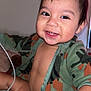 Alexander is registered to the contest to win money with this photo: baby, smiling, child, face, hand, diaper, clothing, jacket, camo, cute, happy, indoors, person, portrait, toddler, skin, young, expression, sitting, chubby